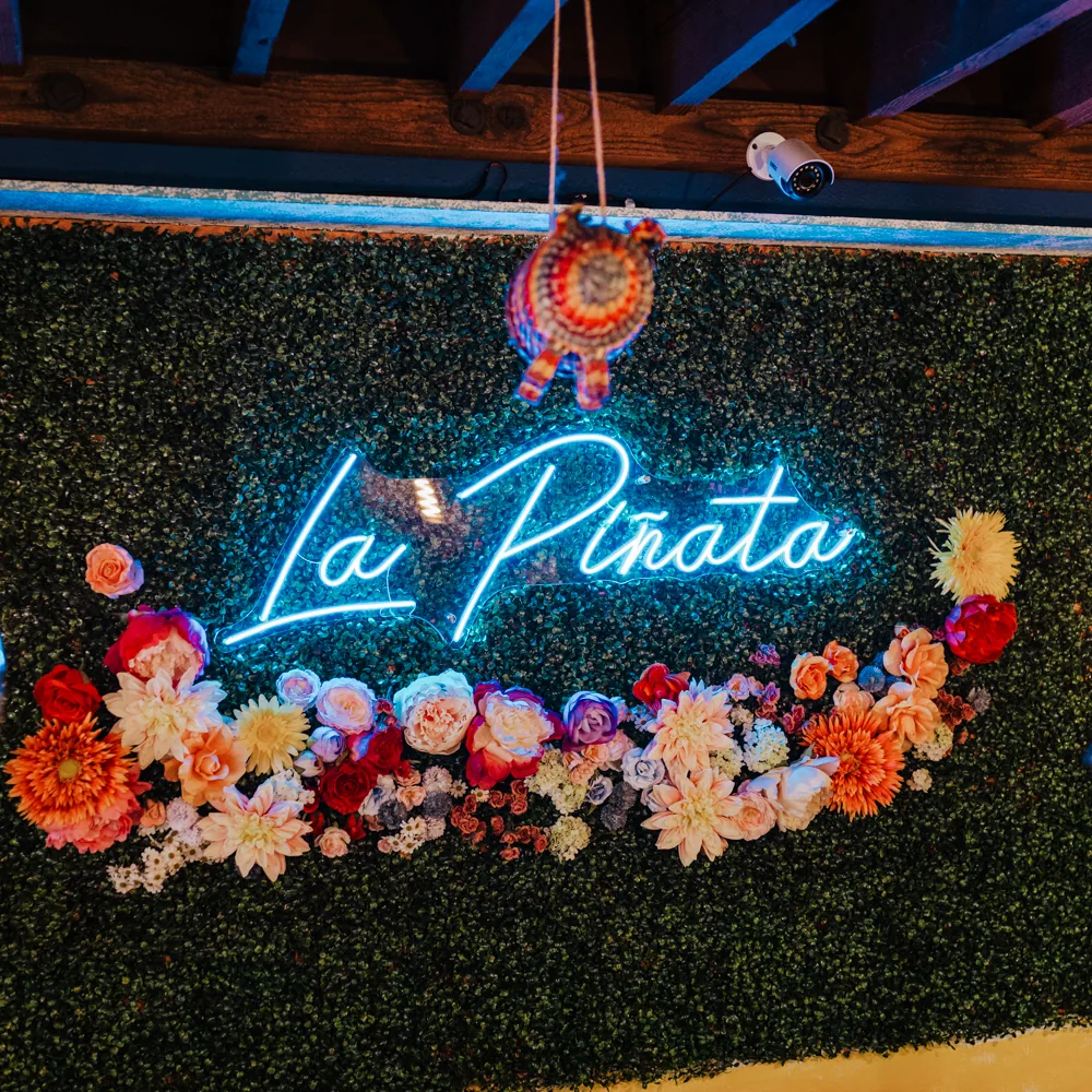 La Piñata neon sign with flowers and hanging piñata